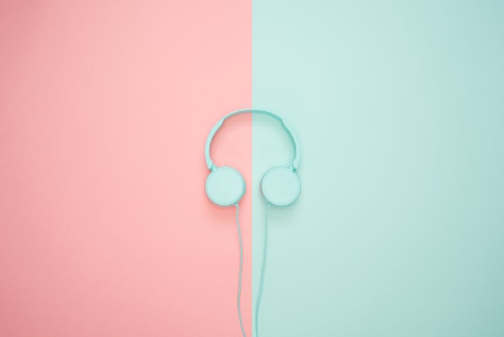 Minimalist headphones on a pink and mint background, artistic and modern.